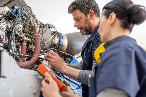 Technicians working on an aircraft engine
