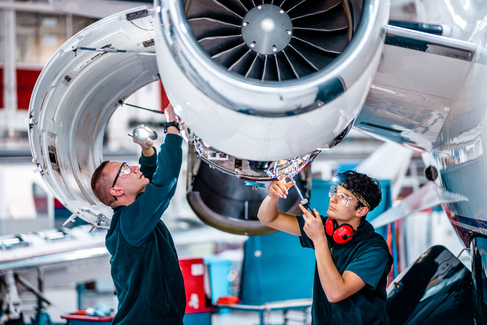 Technicians working on an aircraft engine