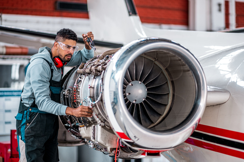 A technician working on an aircraft engine