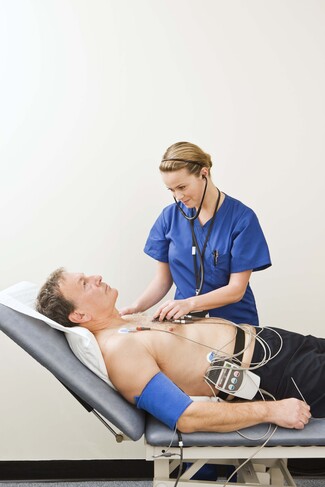 An EKG technician working with a patient
